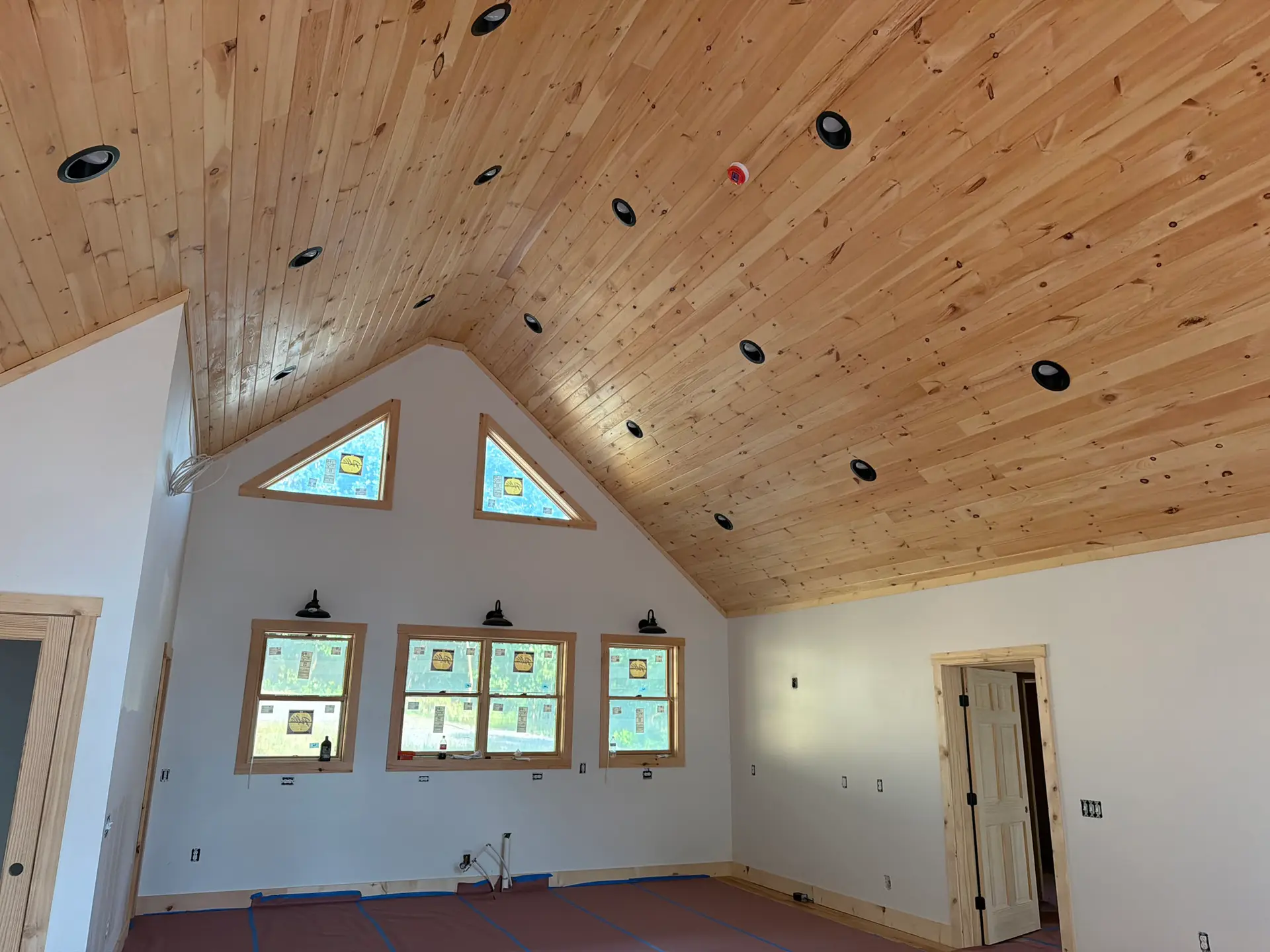 Vaulted cabin interior with a tongue-and-groove wood ceiling and clerestory windows